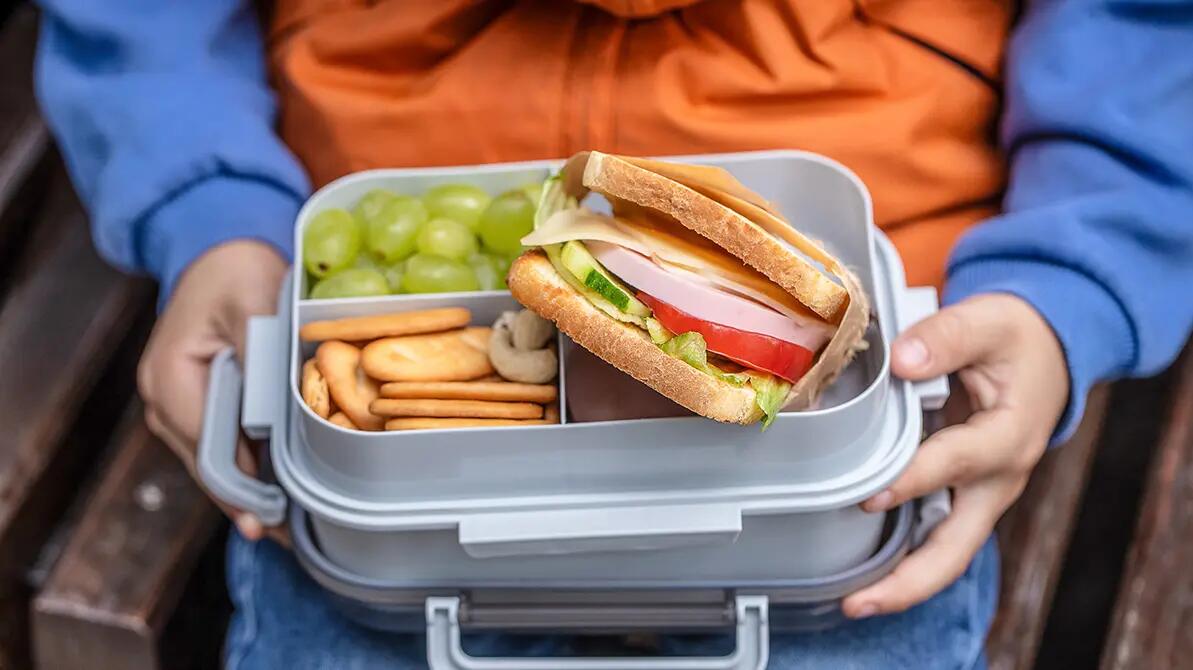 Dziecko trzymające w rękach lunchbox z jedzeniem