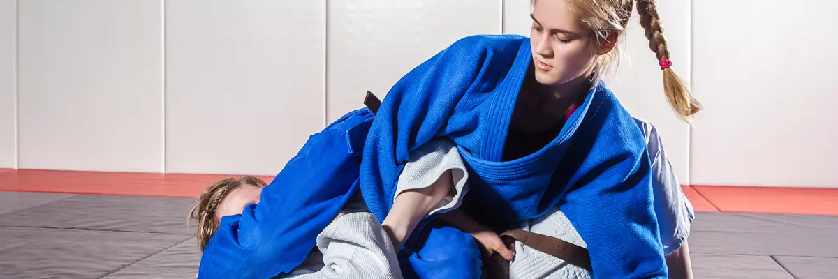 Dwie kobiety trenujące na podłodze duszenia w judo