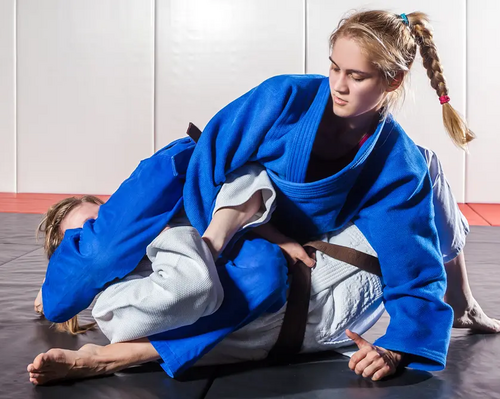 Dwie kobiety trenujące na podłodze duszenia w judo