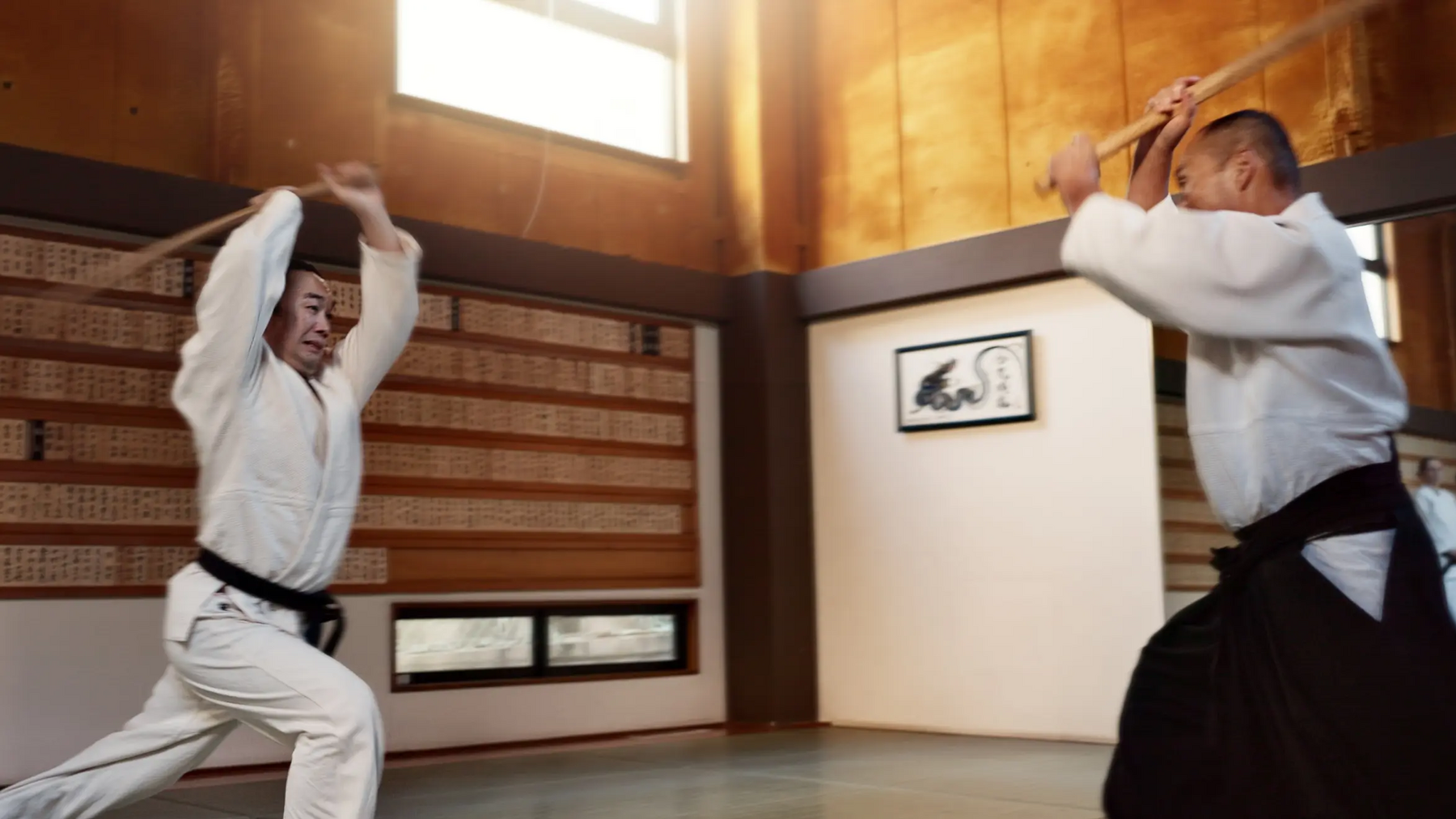 Dwóch mężczyzn z bokkenami w rękach trenujący buki waza aikido