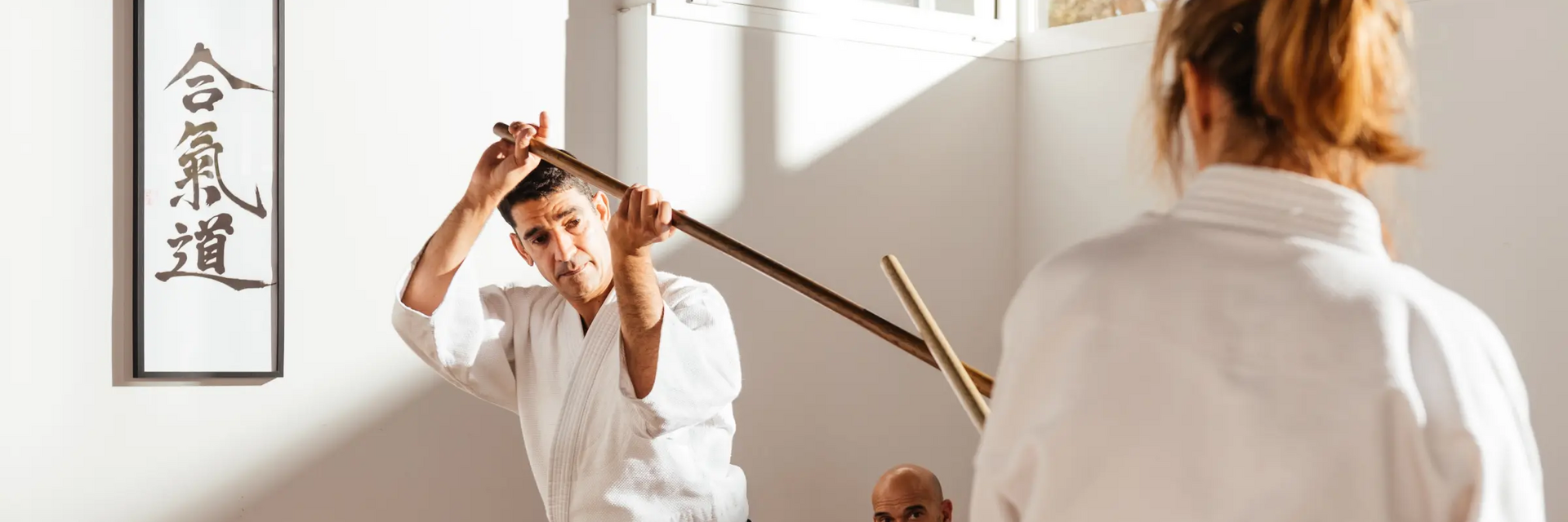 Mężczyzna i kobieta wykonujący trening buki waza aikido z bokkenem