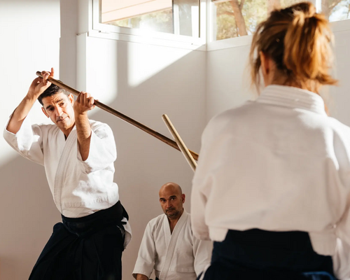 Mężczyzna i kobieta wykonujący trening buki waza aikido z bokkenem