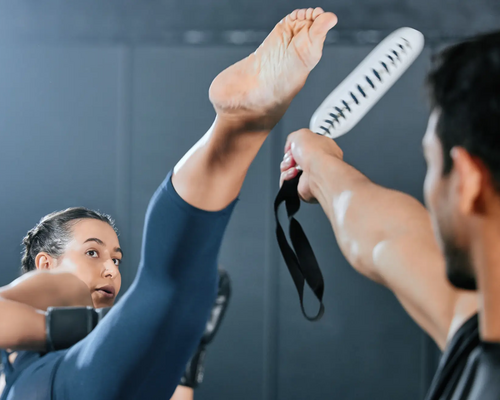 Kobieta trenująca axe kick z mężczyzną