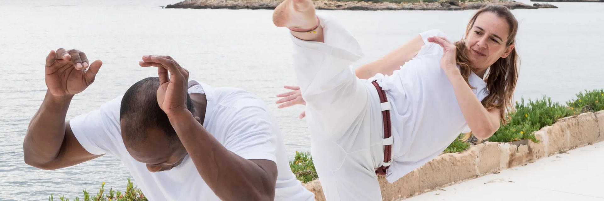 Kobieta z mężczyzną trenujący capoeira kick
