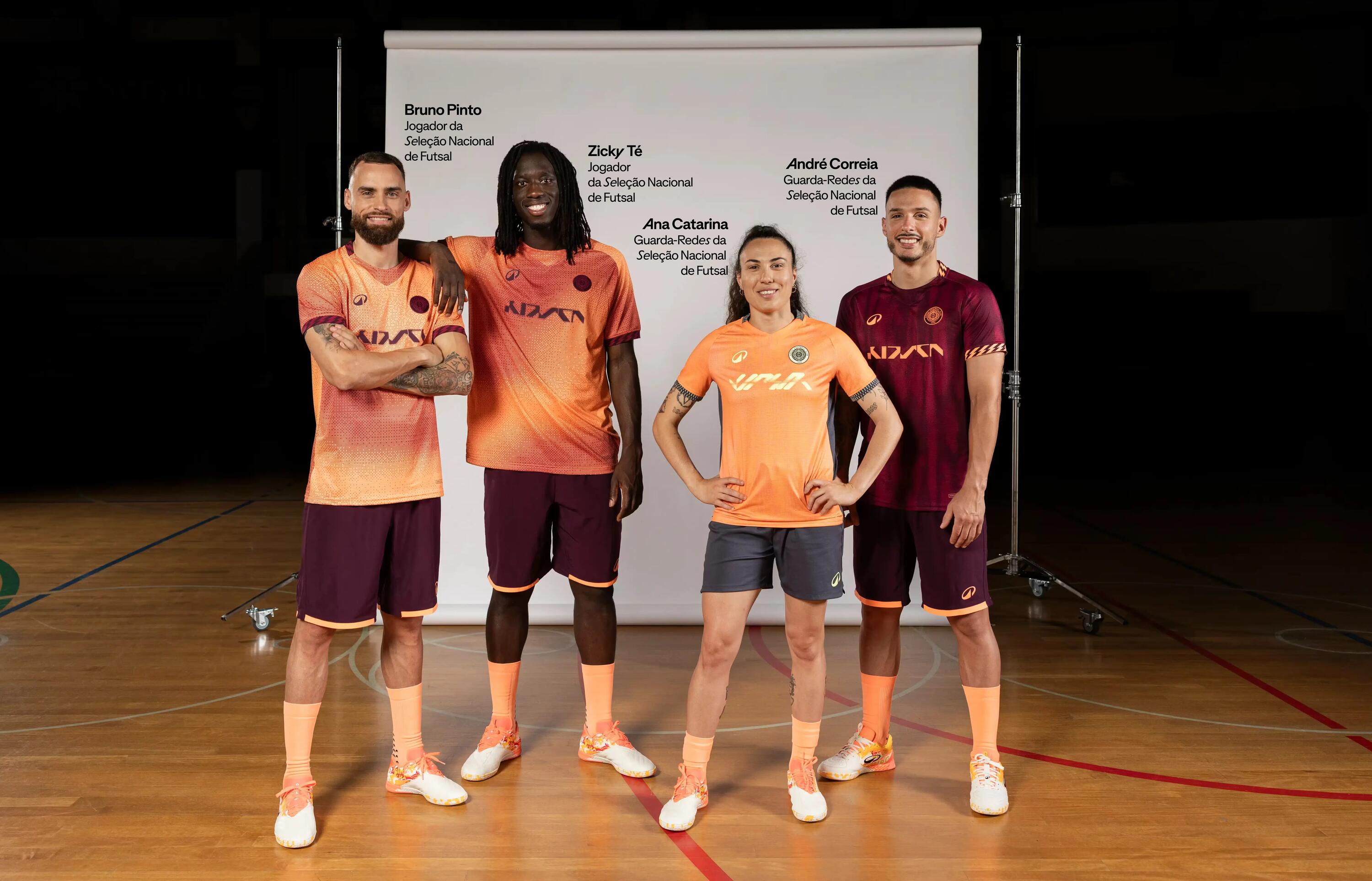 Atletas de futsal com o equipamento oficial laranja e grená da Kipsta em pavilhão desportivo.