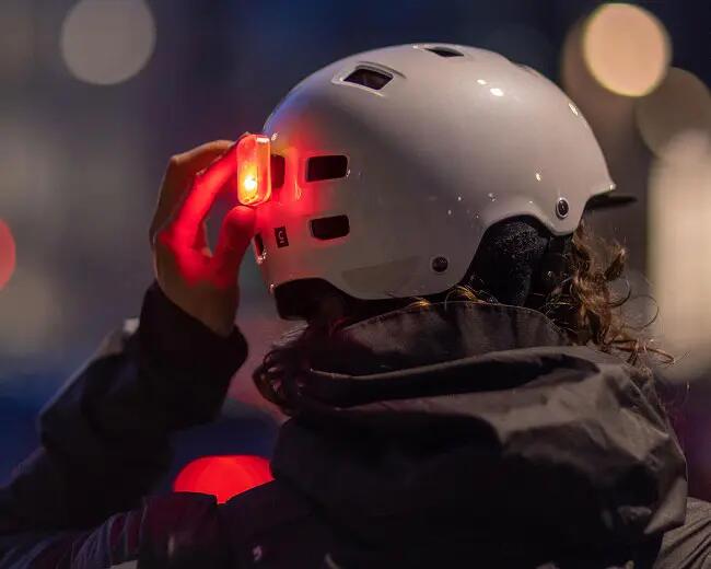 A women is switching on her light on her bike helmet