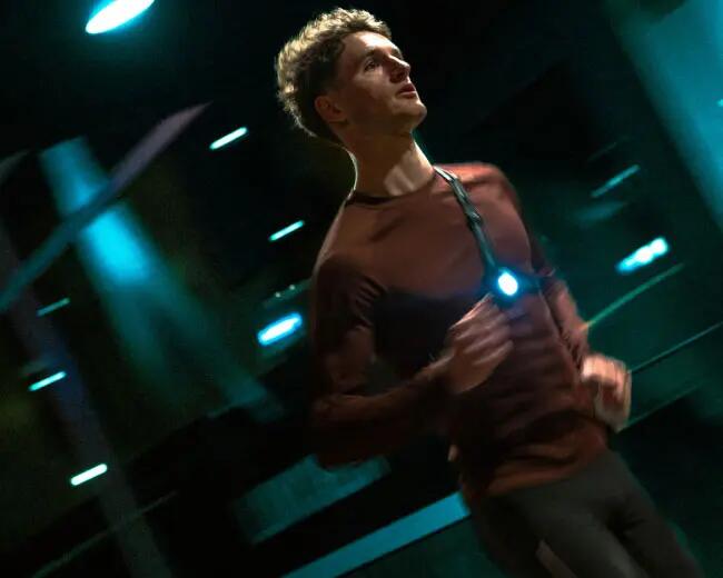 A men is running at night with lights on