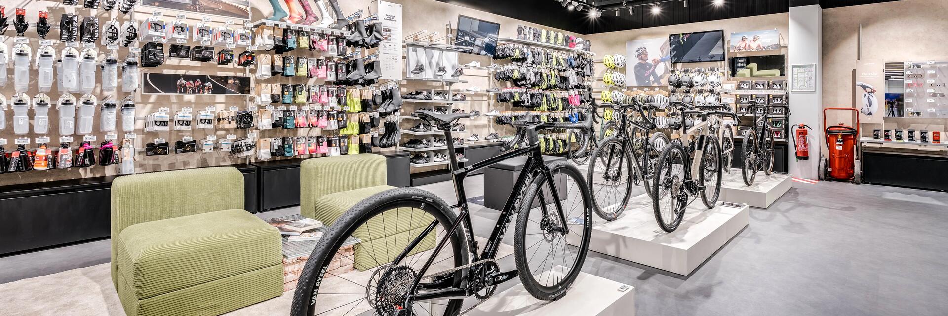 Schwarz-grünes Fahrrad im Vordergrund, unscharfer Hintergrund mit Kieselsteinen und grünem Gras, weißer Text.