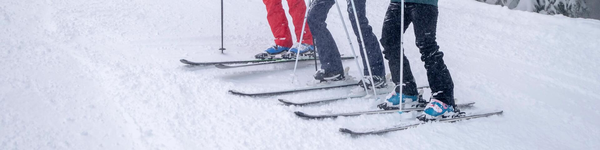 mężczyźni stojący na nartach w śniegu