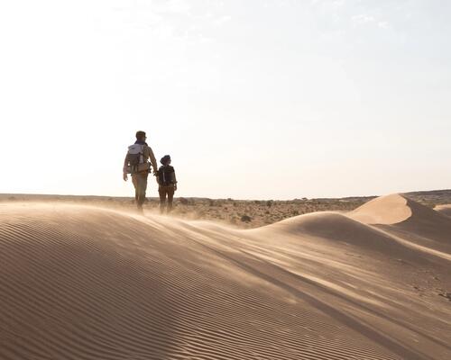 Trekkeurs marchant sur une dune de sable dans le desert