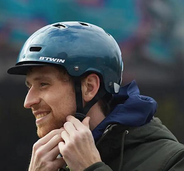 Un uomo che mette allegramente il casco da bici.