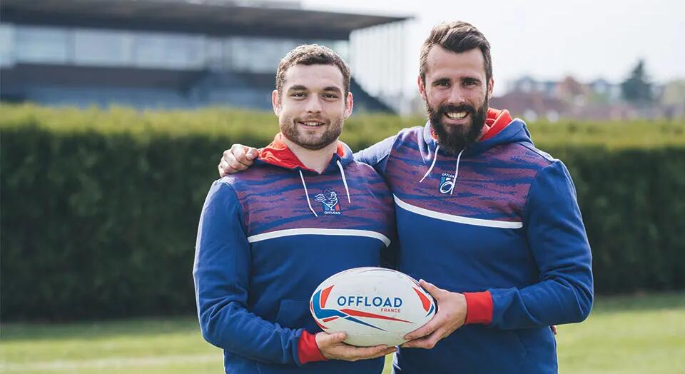 two men posing with a rugby ball