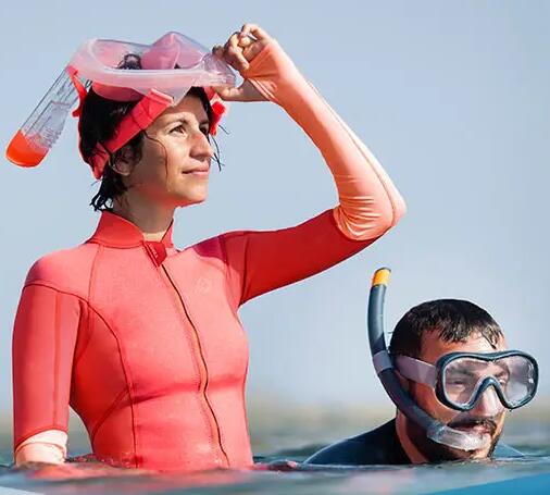 woman wearing a snorkeling mask on her head and man wearing j shaped snorkel