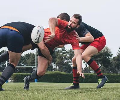 Men tackling player in rugby game