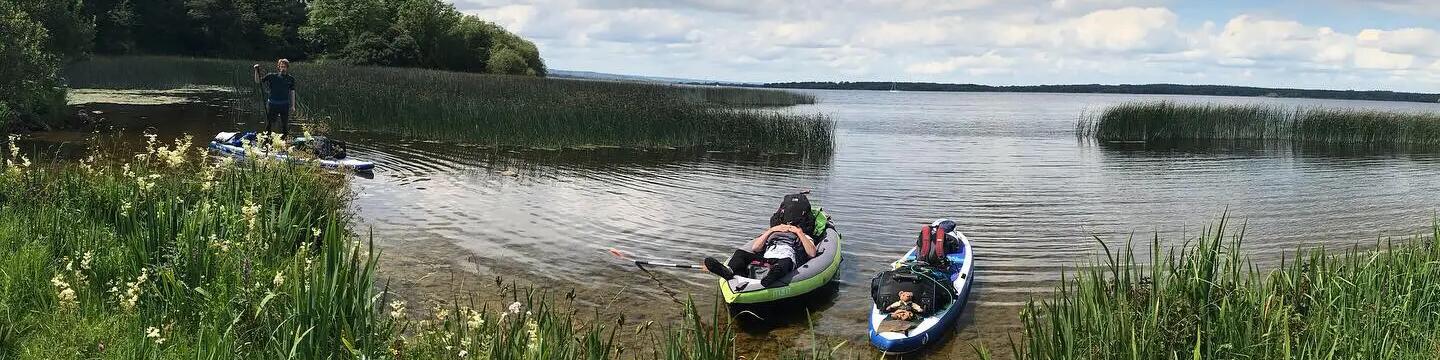 2 people relaxing on kayaks in the river