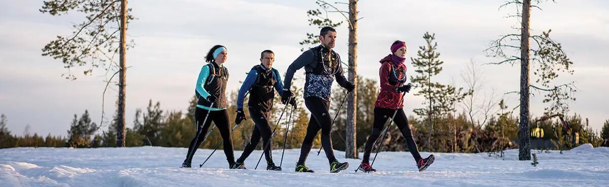 mężczyźni i kobiety trenujący nordic walking zimą