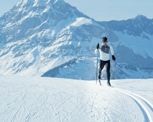 mężczyzna w odzieży narciarskiej trenujący narciarstwo biegowe