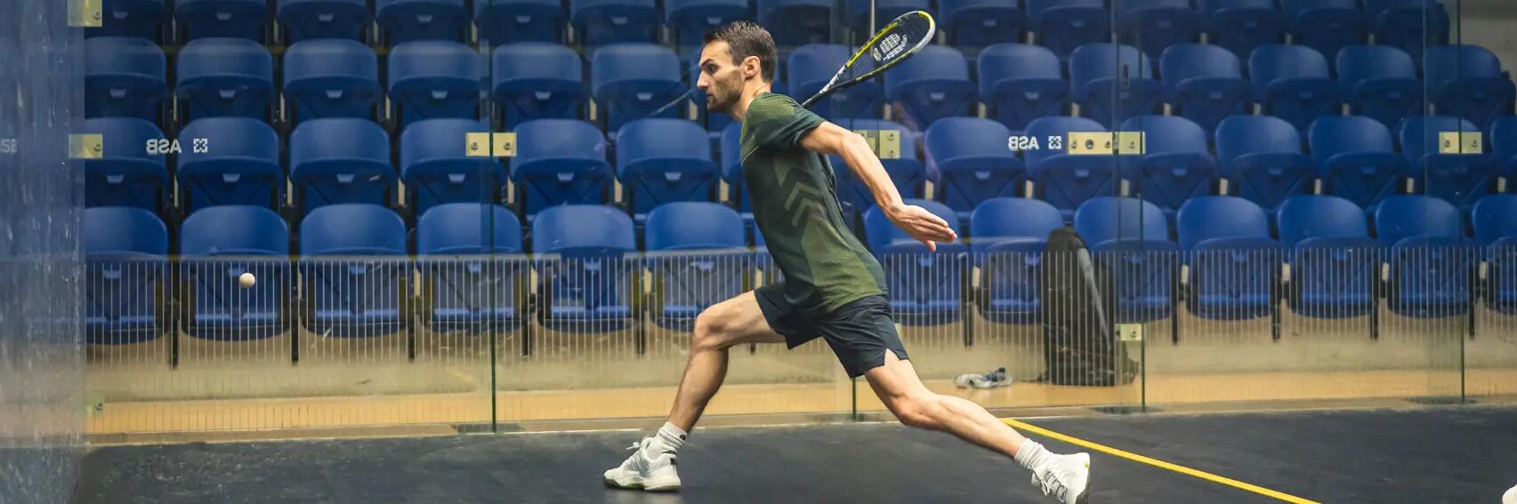 Mężczyzna w stroju do squasha grający na korcie według zasad gry w squasha