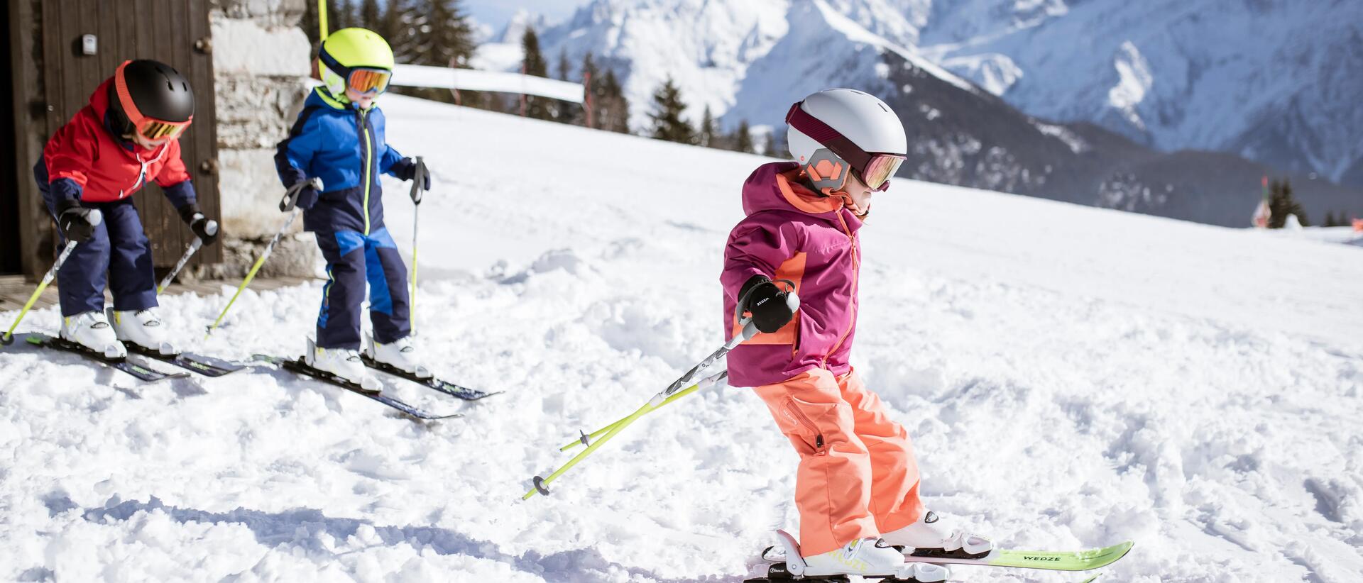 dzieci zjeżdżające na nartach