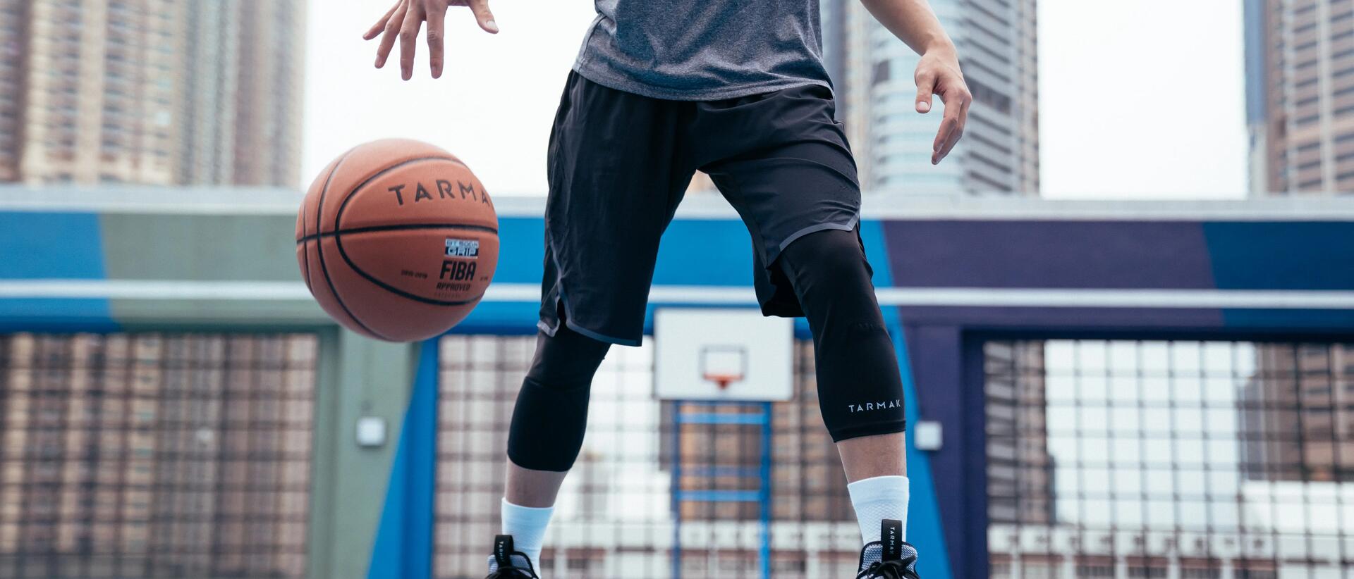 mężczyzna stojący na boisku w stroju do gry w koszykówkę z piłką do koszykówki