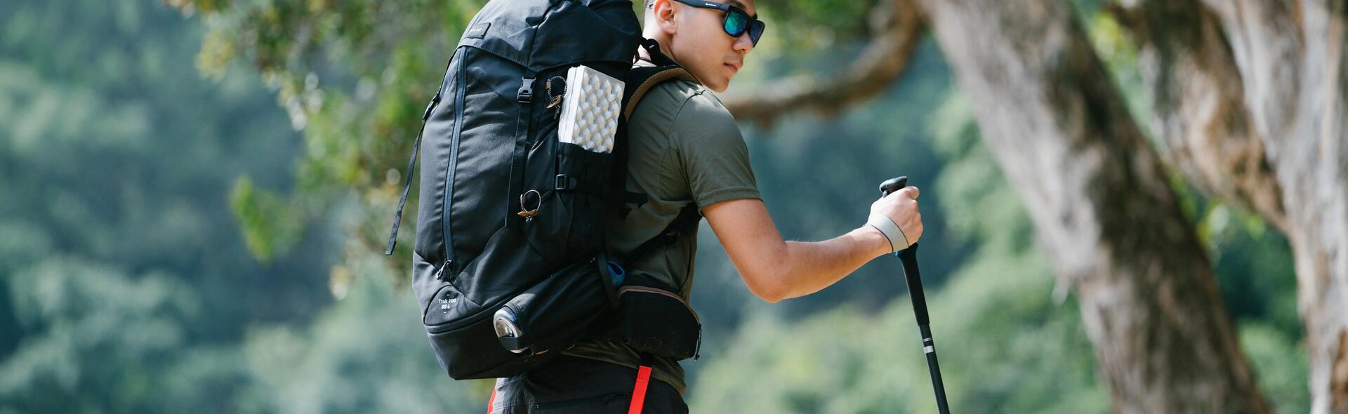 mężczyzna z plecakiem na plecach i kijem trekkingowym w ręce