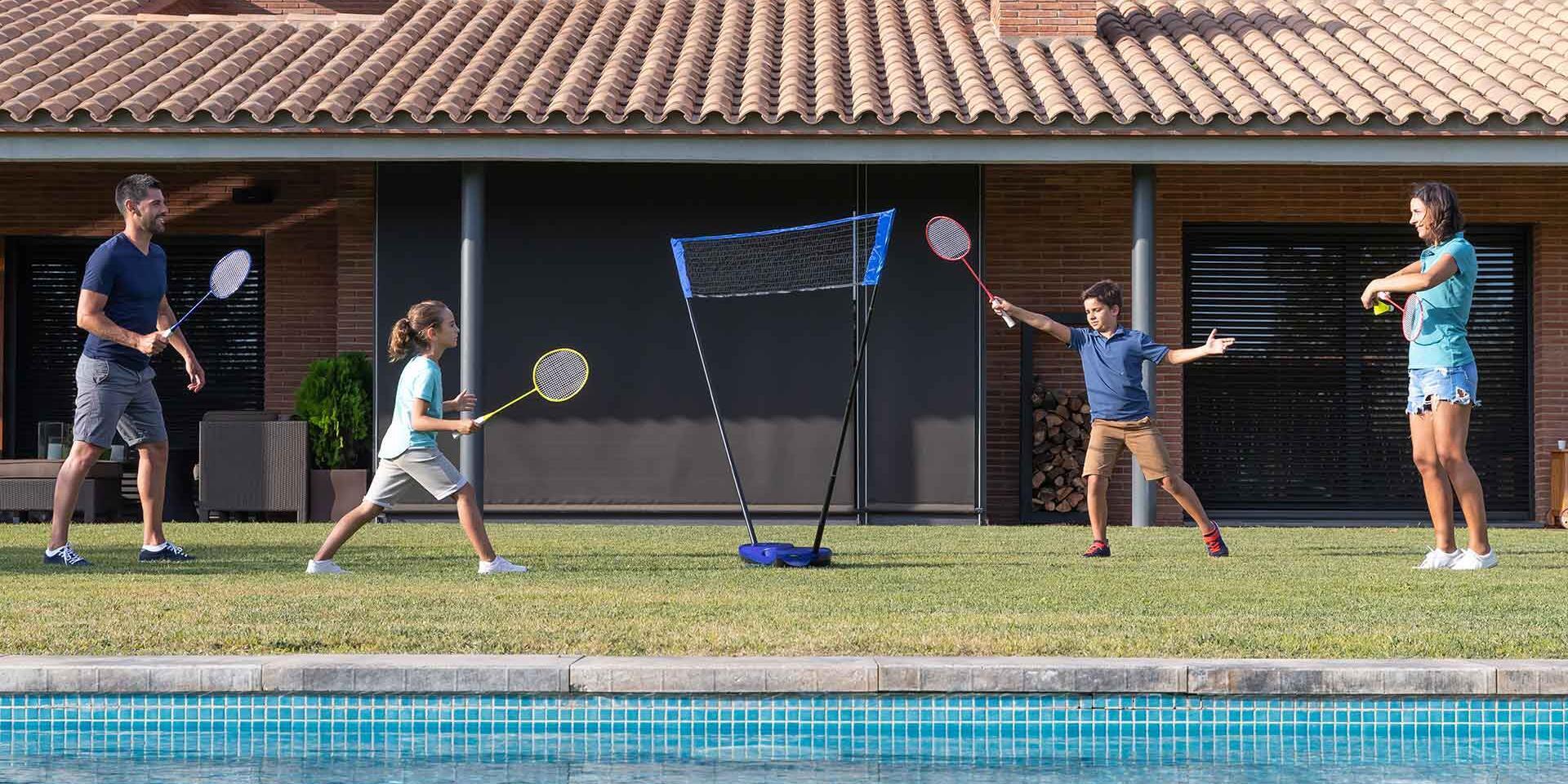 En familj som spelar dubbelmatch utomhus