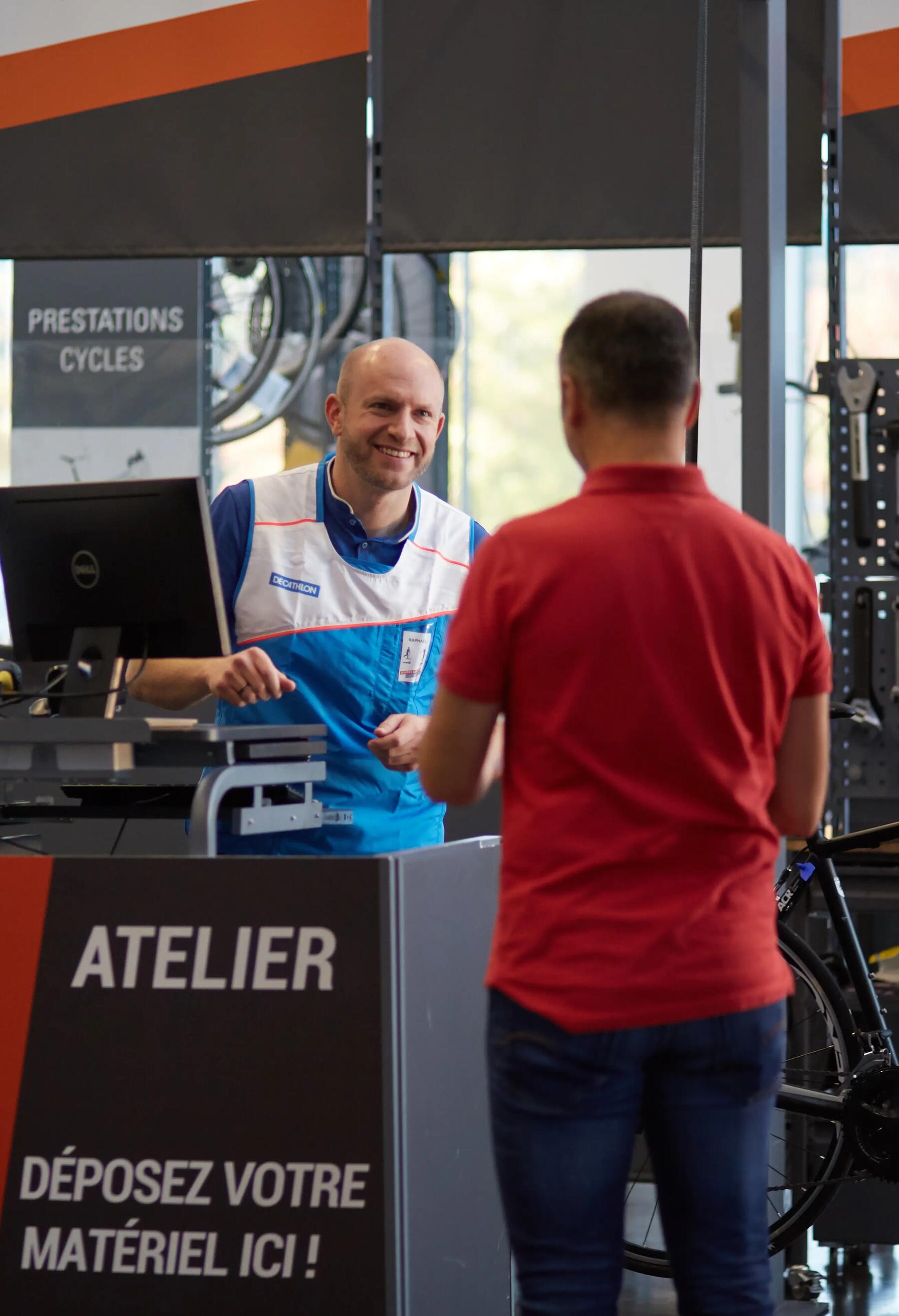 Photo d'un vendeur Decathlon proposant un service à l'atelier vélo à un client