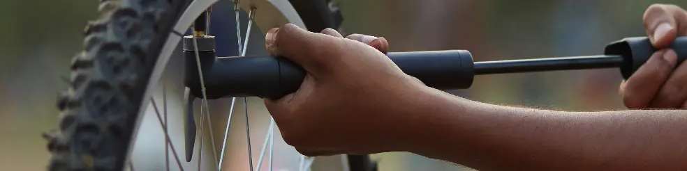 Man inflating a mountain bike tyre with a decathlon hand pump