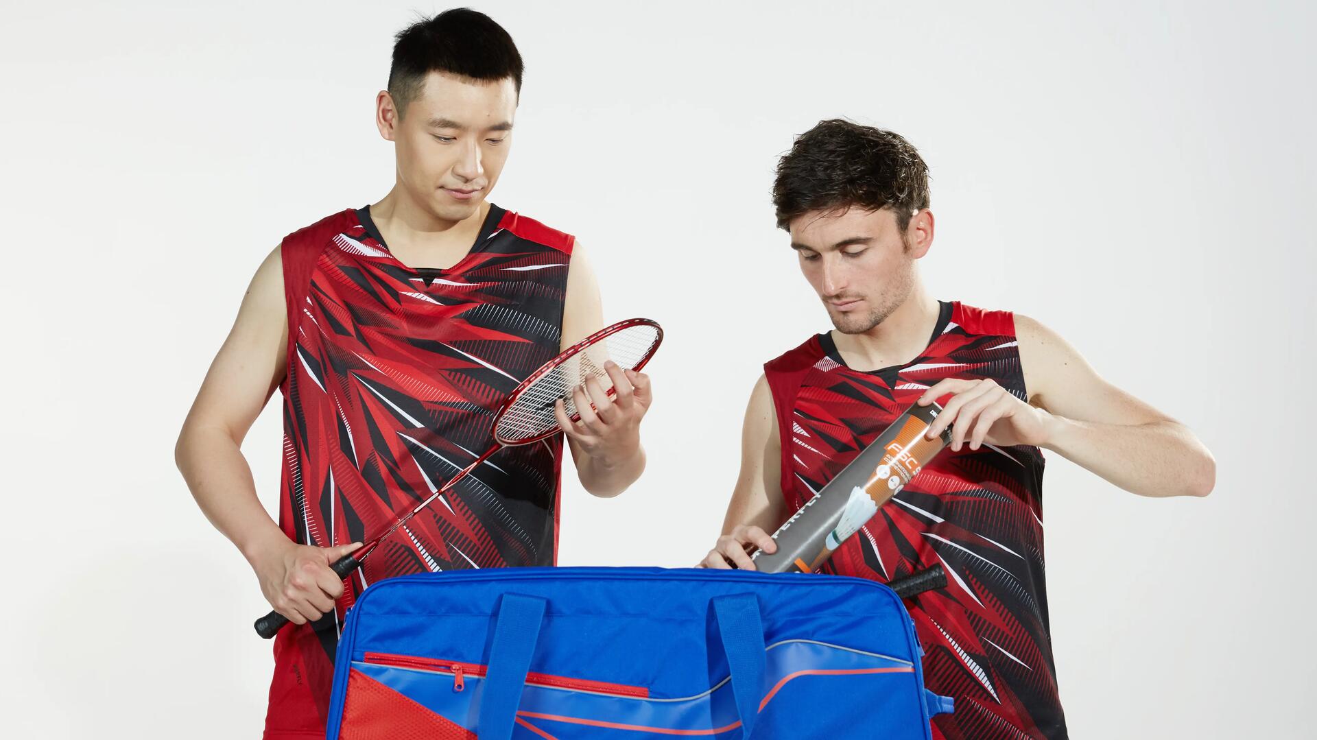 mężczyźni w strojach do gry w badmintona stojący przy torbie do badmintona