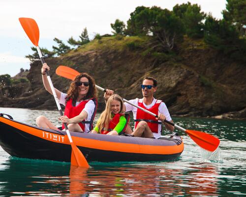 Two people smile in their tandem kayak.