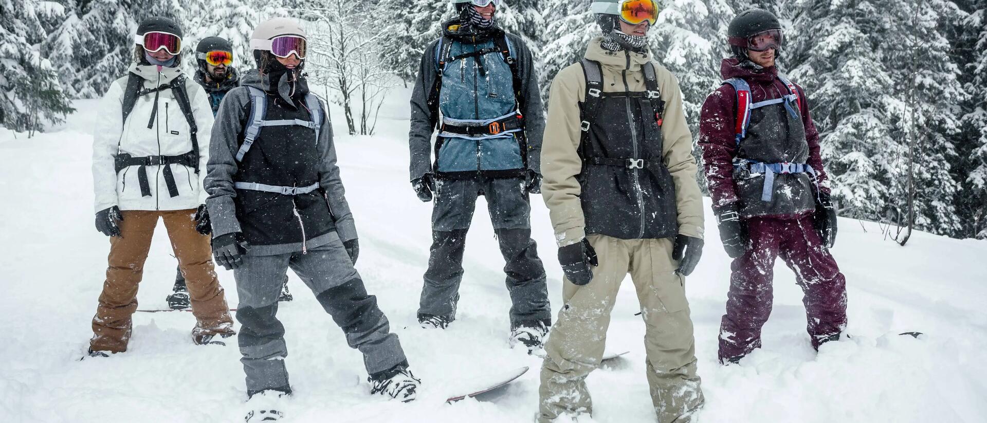 mężczyźni w strojach snowboardowych stojący na śniegu