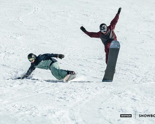 mężczyźni w kaskach i goglach jadący na deskach snowboardowych 
