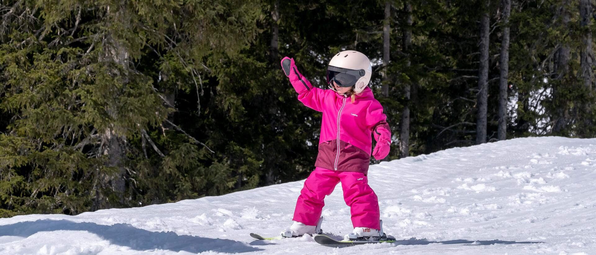 dziewczynka w różowym stroju narciarskim