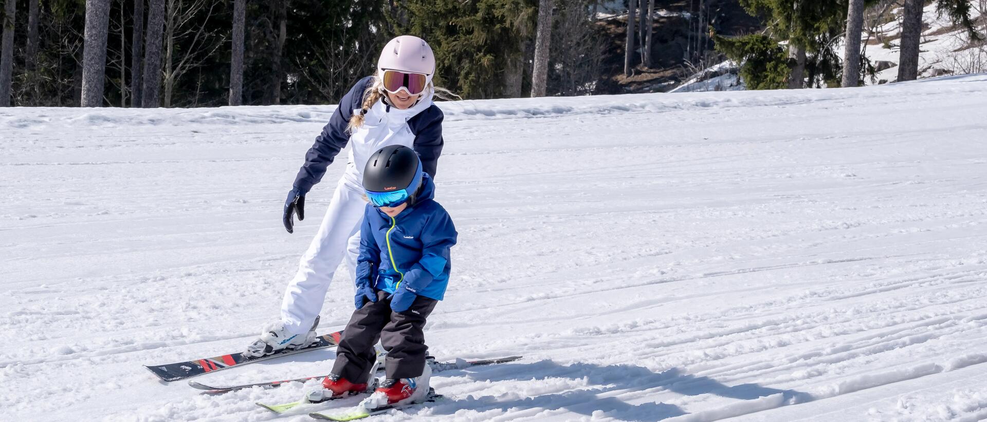 kobieta i dziecko zjeżdżają ze stoku na nartach