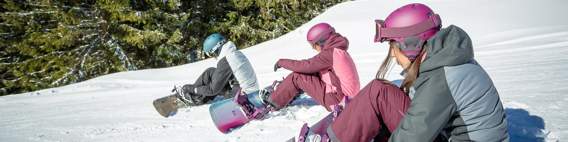 ludzie w strojach snowboardowych siedzący na śniegu