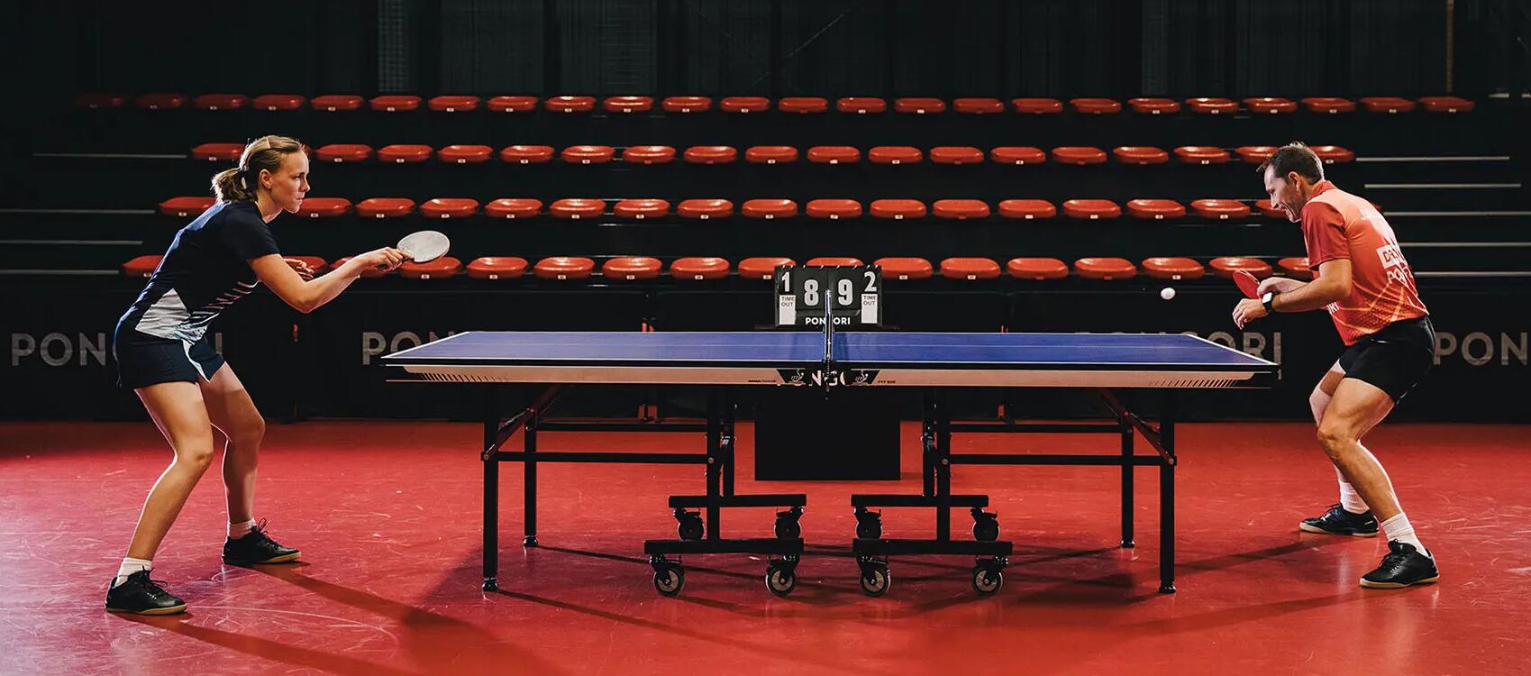 Man and woman competing in table tennis tournament 