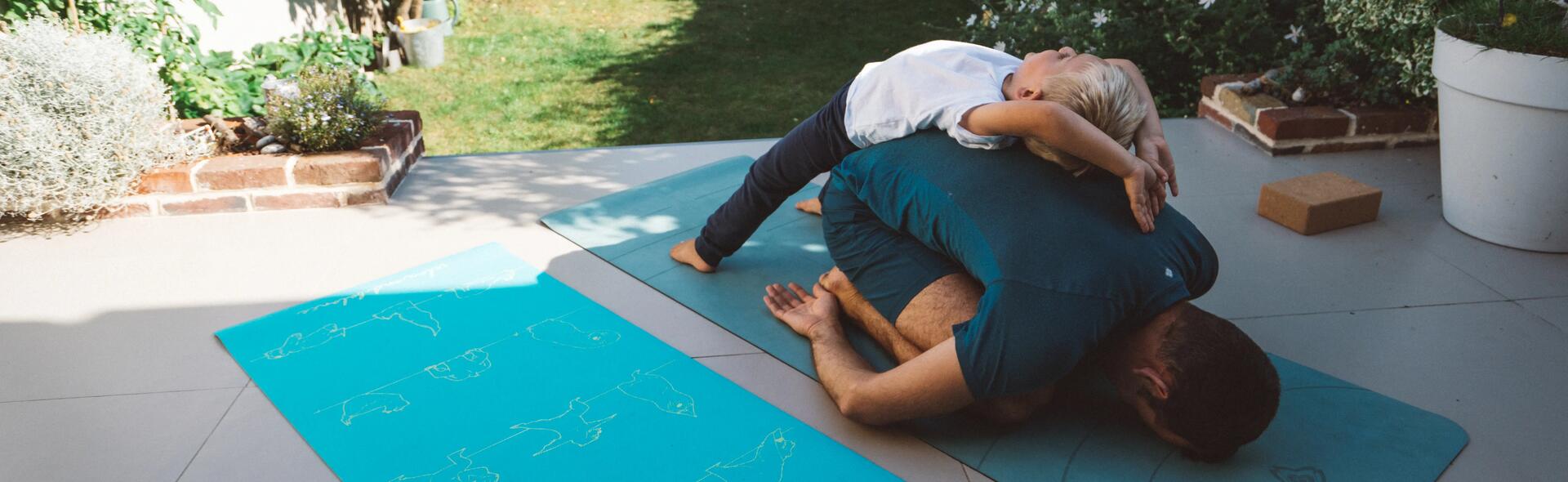 en pappa och hans son gör yogaövningar