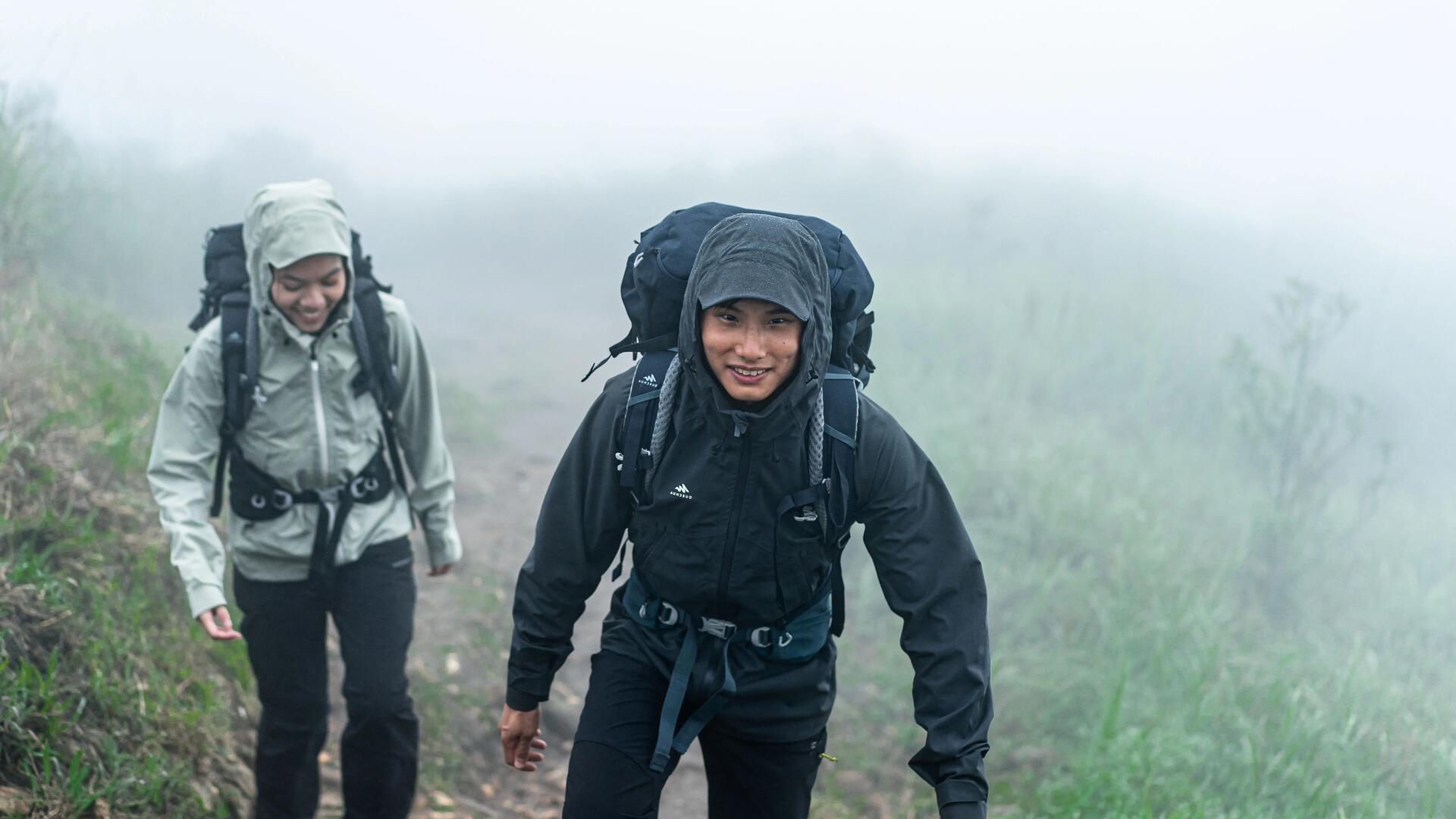 kobieta i mężczyzna idący szlakiem w kurtkach trekkingowych przeciwdeszczowych