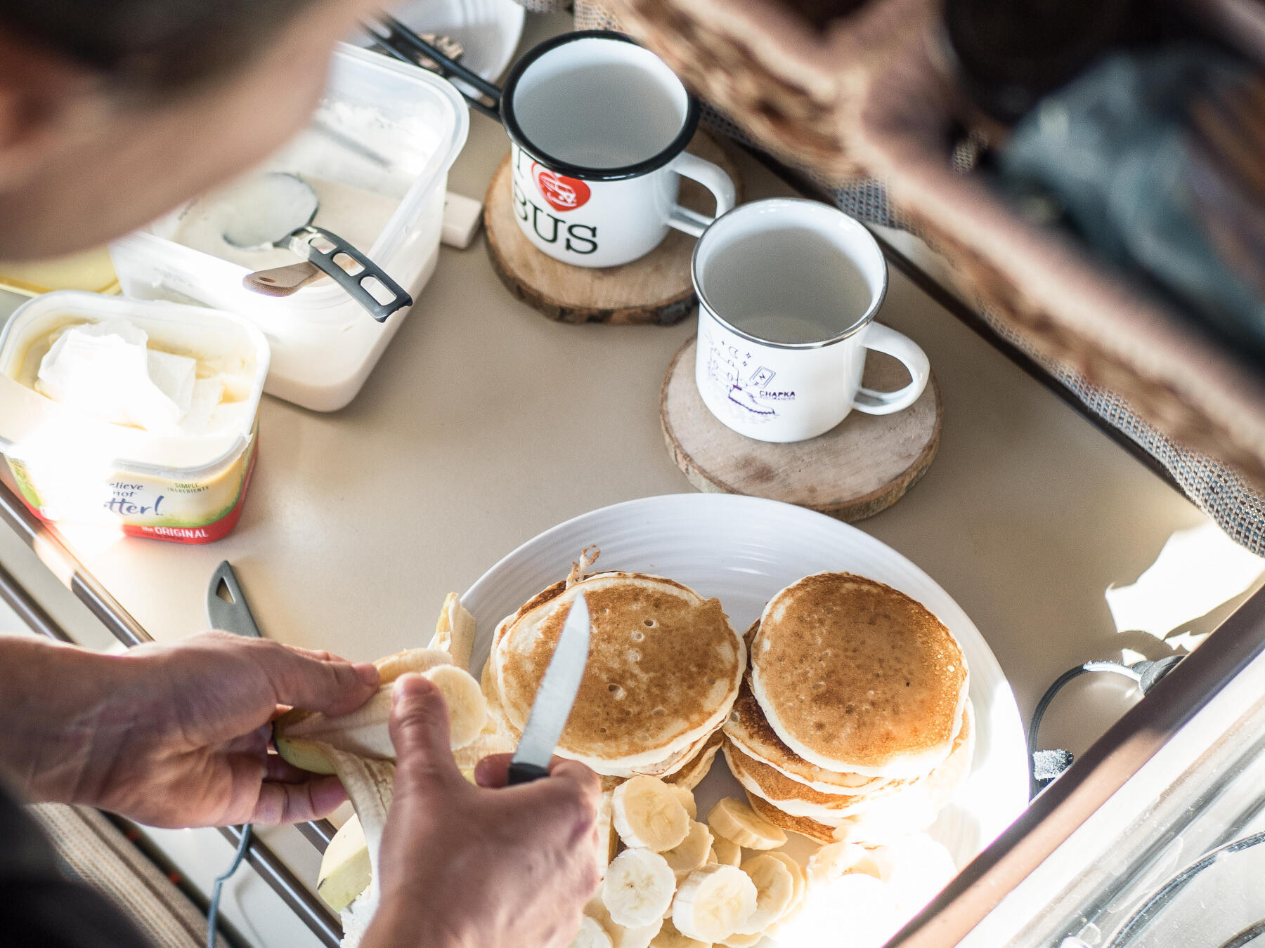 Photo d'un petit déjeuner copieux avec des pancakes et des bananes en van pendant un roadtrip