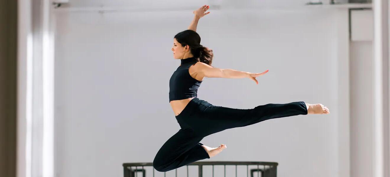 kobieta w odzieży do tańca wykonująca figurę taneczną skacząc