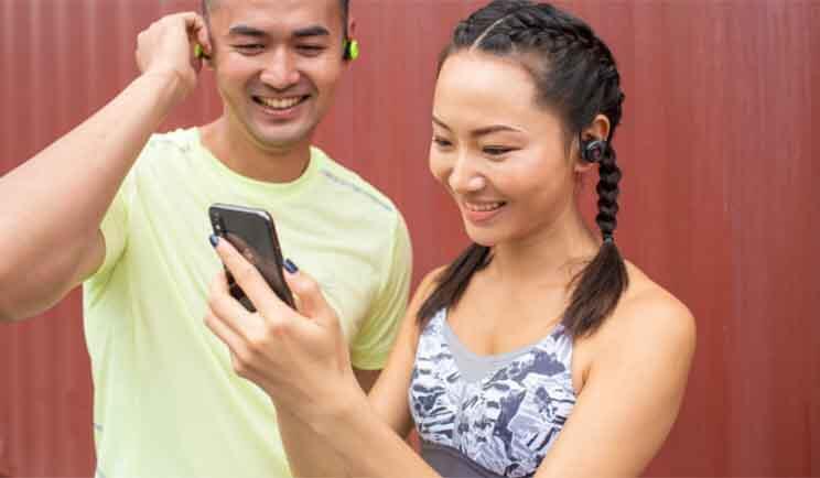 Un ragazzo e una ragazza vestiti da palestra usano il cellulare