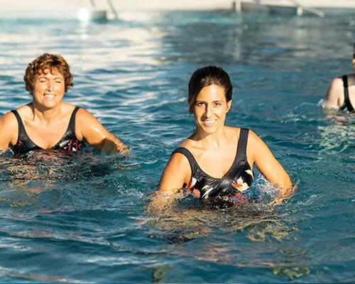 kobiety w strojach kąpielowych trenują aqua aerobik w basenie