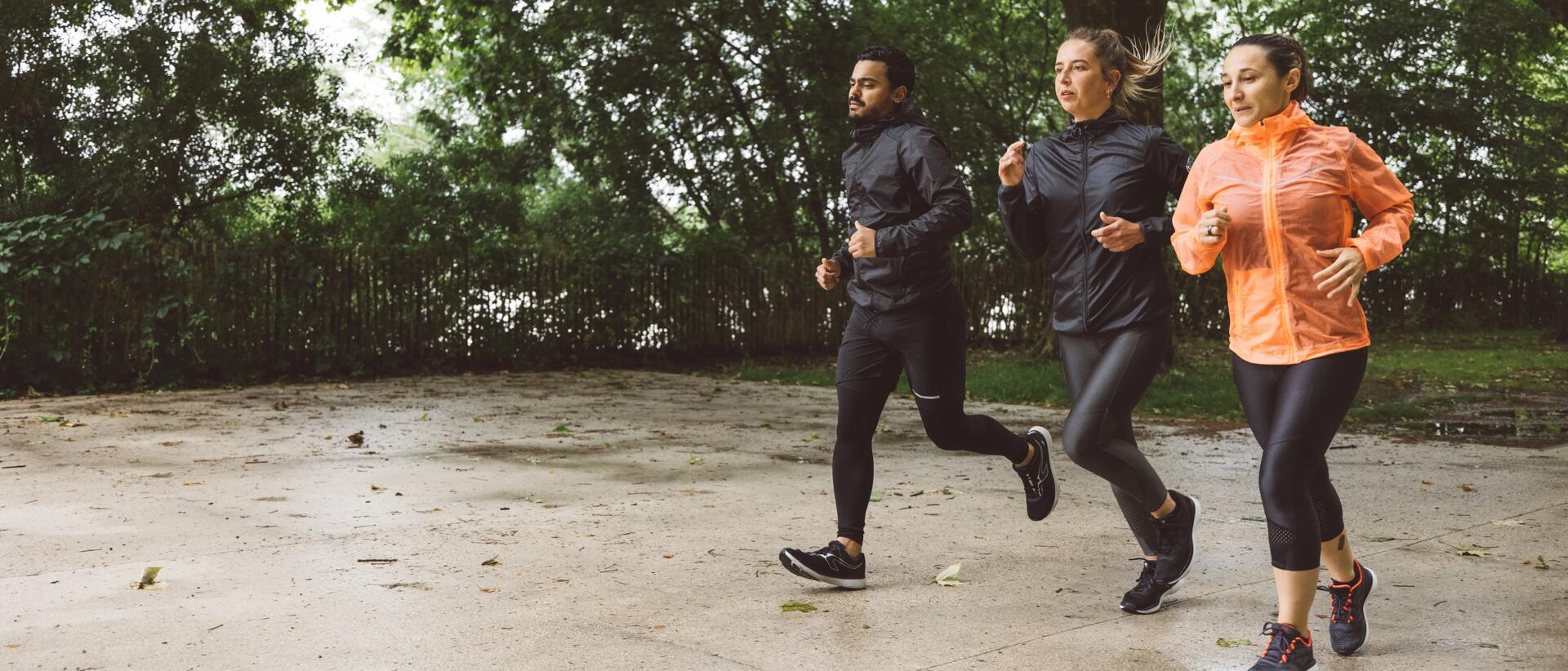 Three people running in rainy conditions