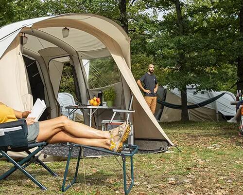 Kids playing outside of camping tent.