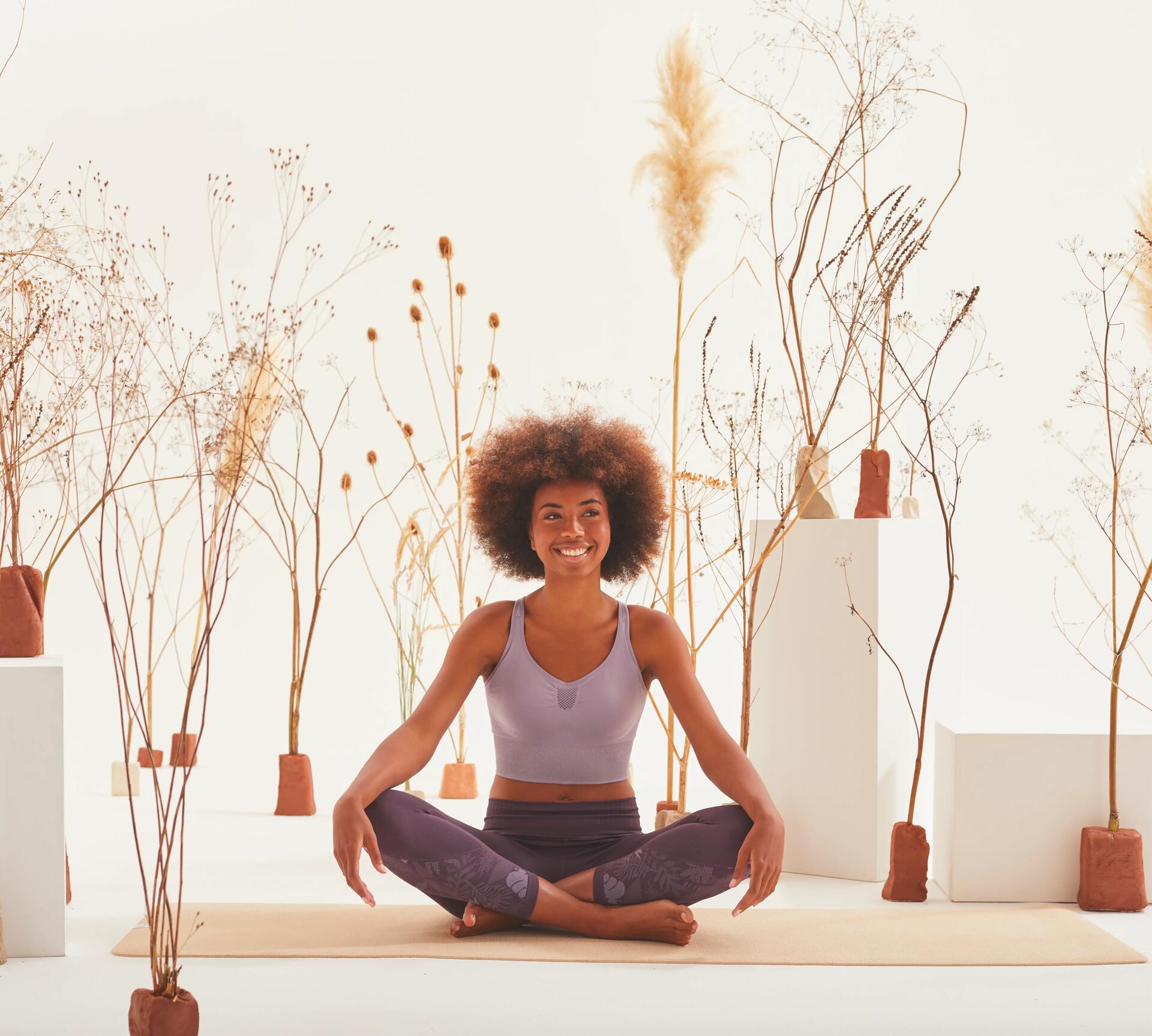 woman sititng in a yoga pose smiling