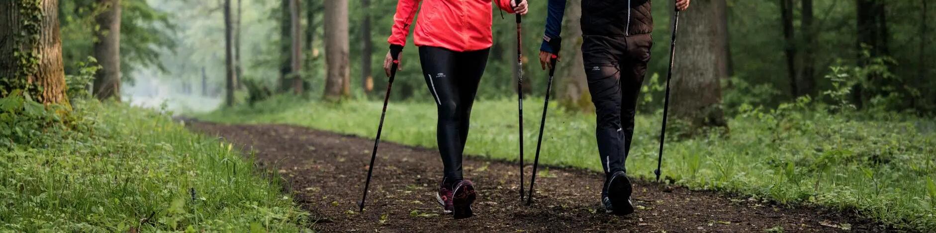 Two people walking on trail using nordic poles