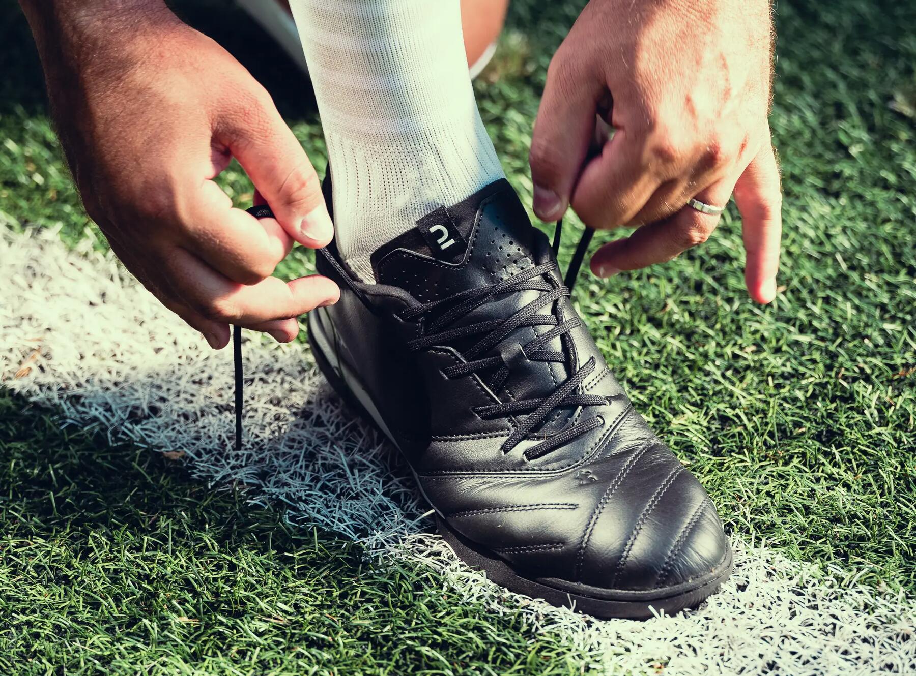 Man tying football boot