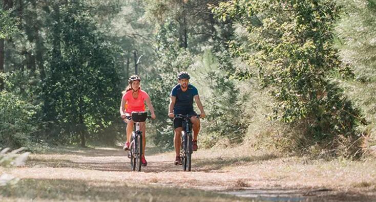 Man and woman riding bike in nature