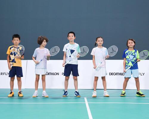dzieci stojące z rakietami do gry w badmintona w rękach na boisku 