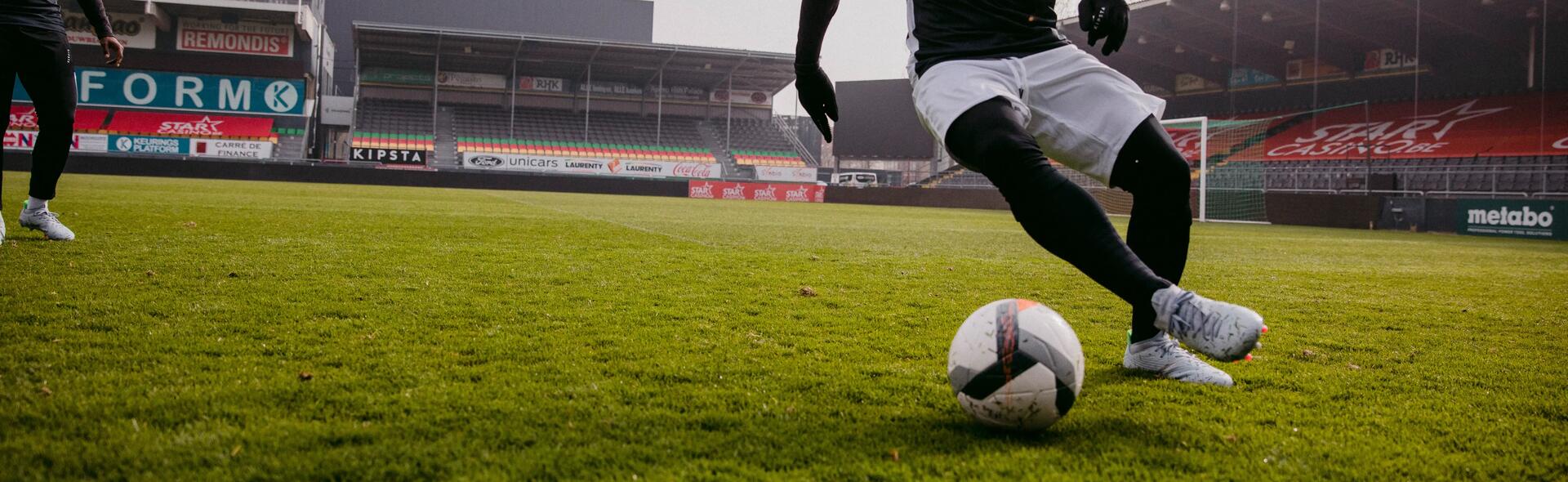 Man dribbling football on the pitch